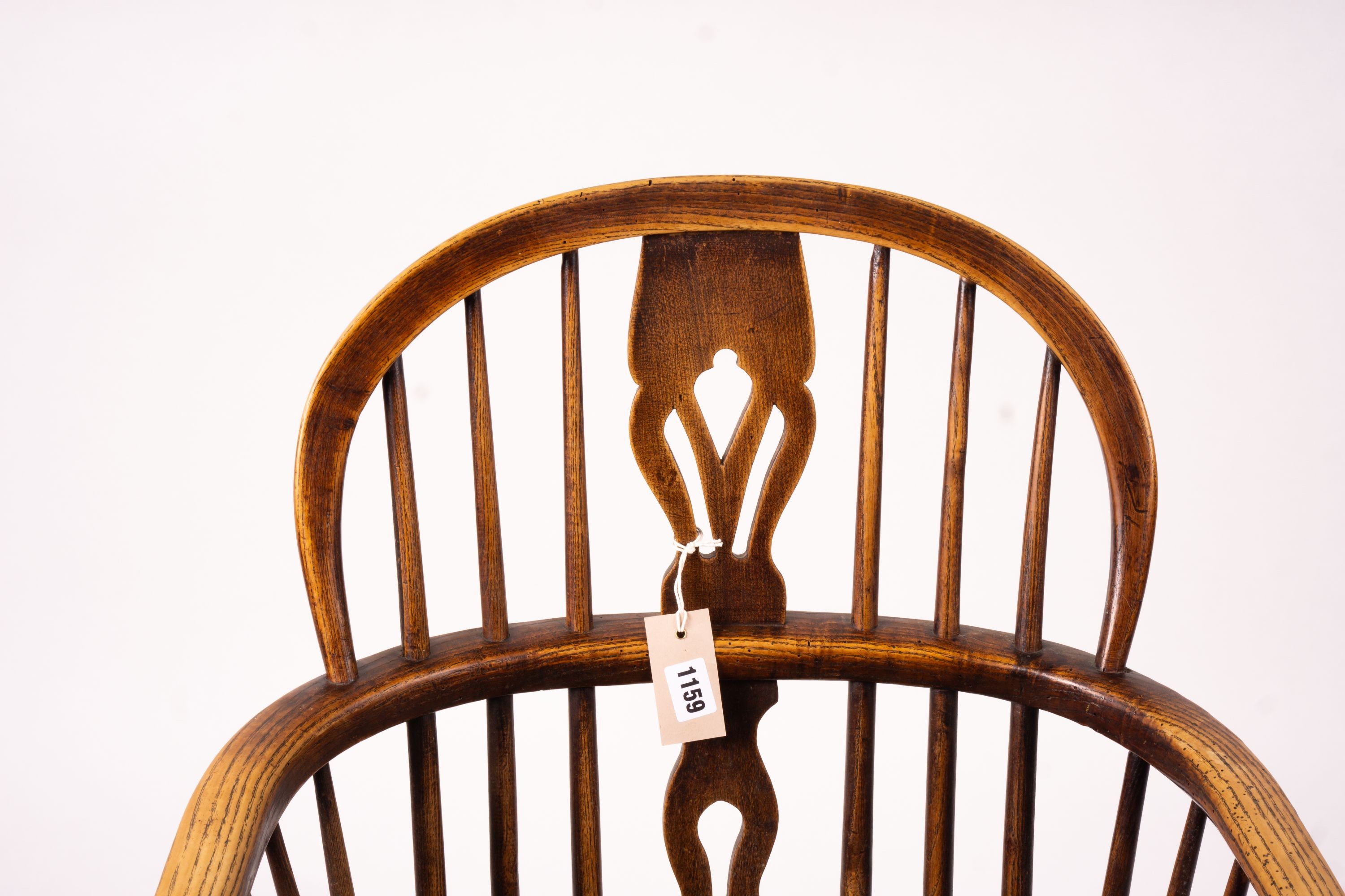 A mid 19th century ash and elm Derbyshire area Windsor elbow chair, together with a 19th century yew and elm Windsor wheel back chair with crinoline stretcher